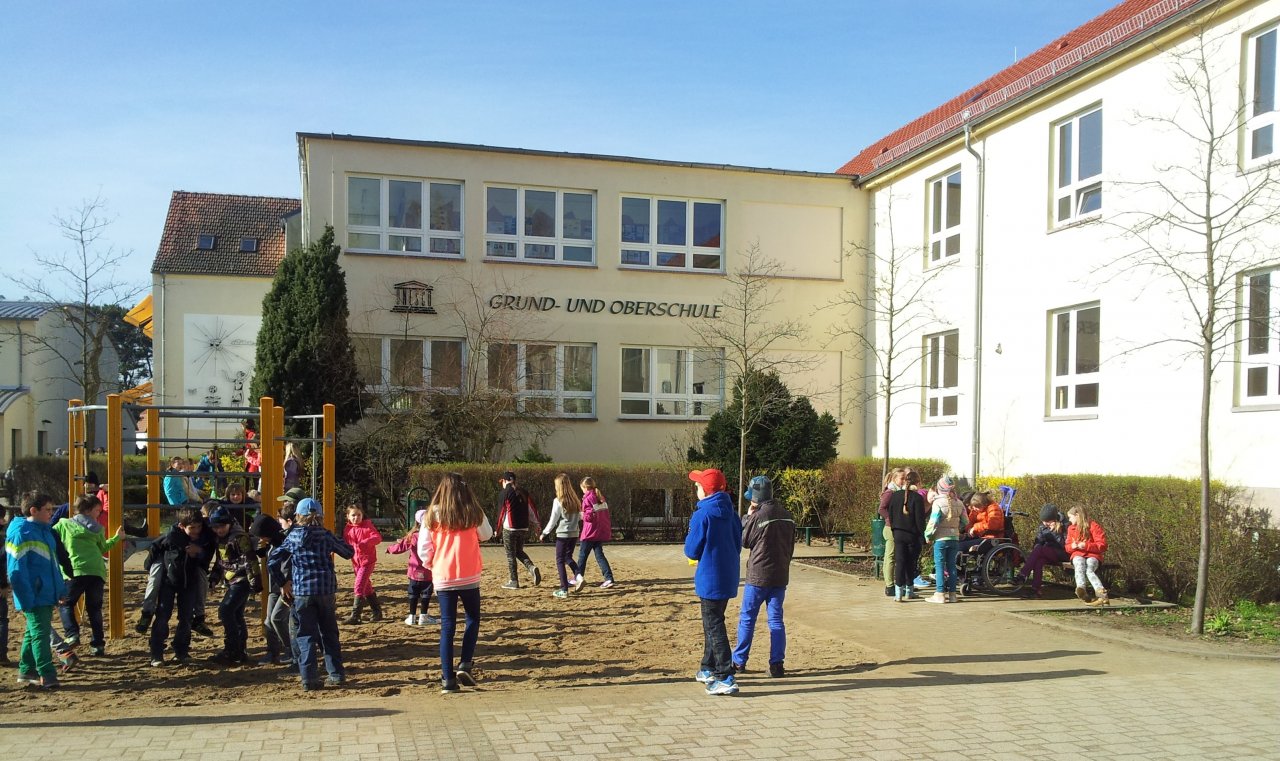 Jugendliche spielen vor dem Schulgebäude 