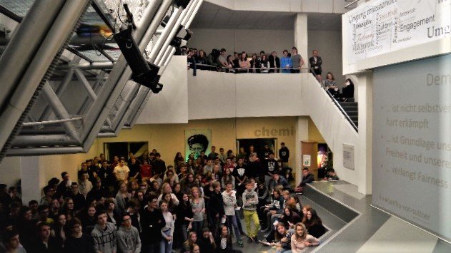 In der Aula des Bertha-von-Suttner-Gymnasiums steht die Schulgemeinschaft und schaut gebannt zur Bühne