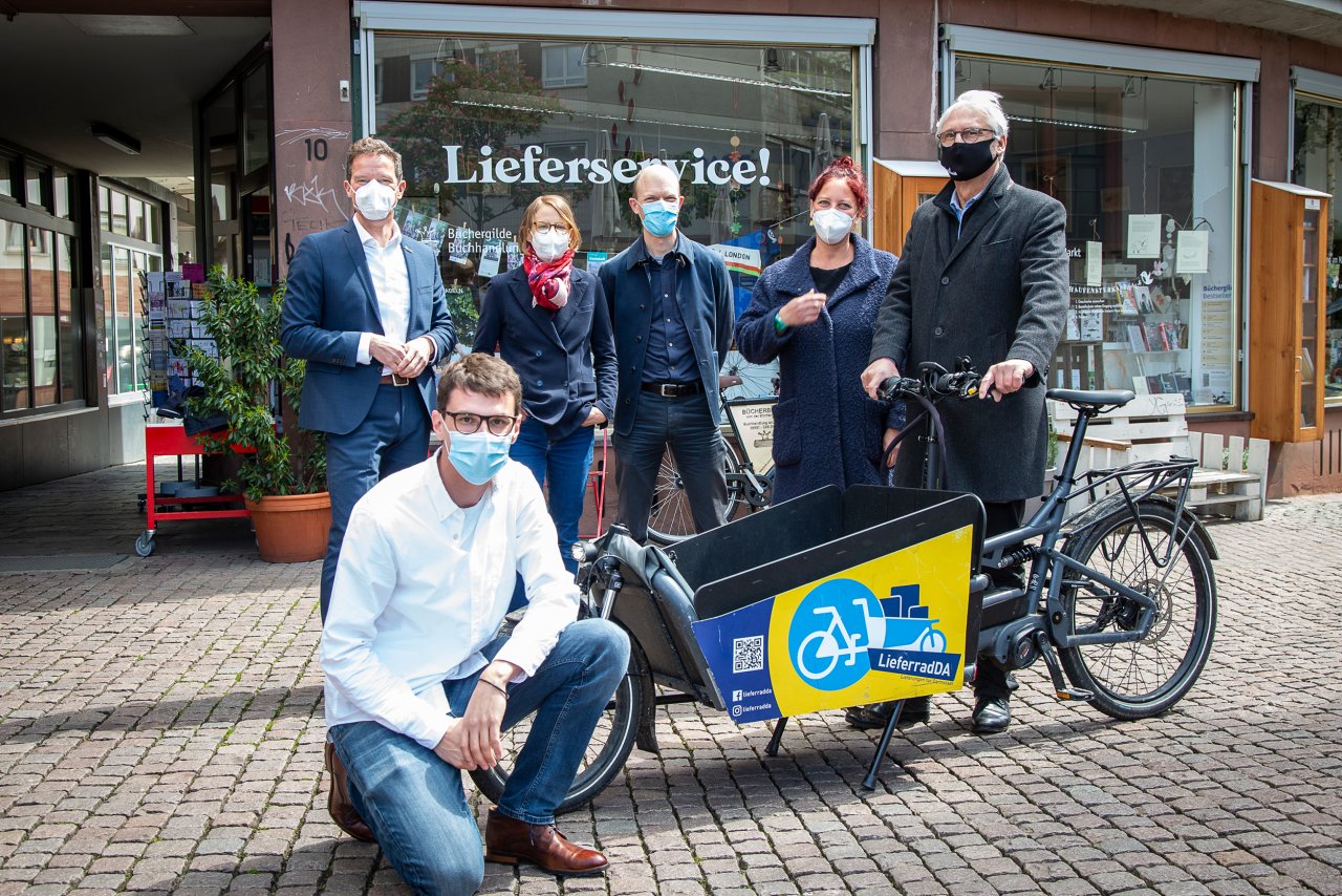 LieferradDA - ein Radlieferdienst für Darmstadt: Oberbürgermeister Jochen Partsch (rechts) mit v.l.n.r.: Prof. Dr. Kai-Oliver Schocke (FRA-UAS) - h_da-Student Florian Treiber - Prof. Dr. Johanna Bucerius und Prof. Dr. Axel Wolfermann (h_da) - Imke Karrock - Inhaberin Buchhandlung am Markt.