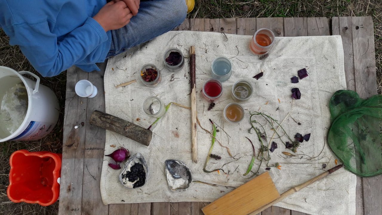 Junges Kind, Bunt gefüllte Gläser mit Naturmaterialien wie Blumen, Muscheln und Gräser