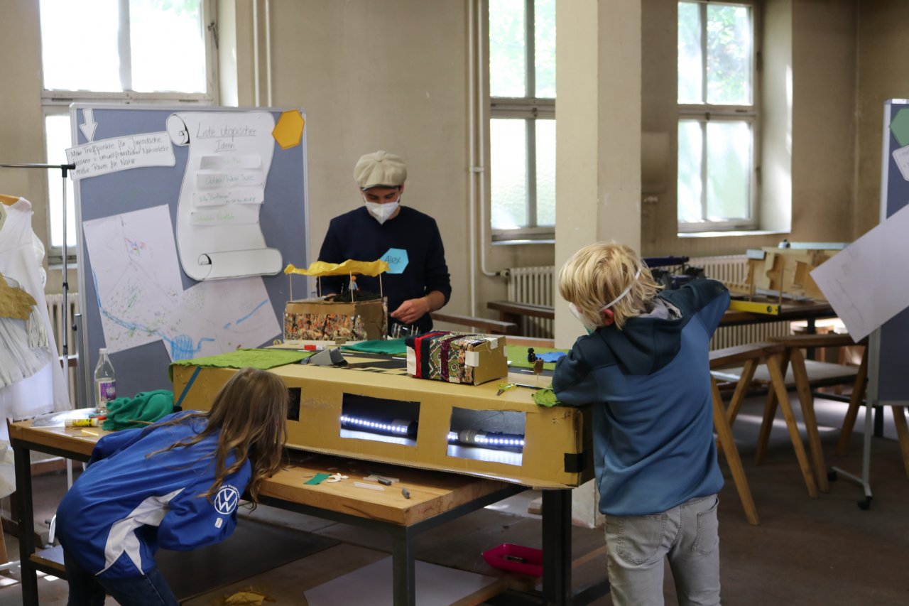 Zwei Jugendliche Arbeiten an einem großen Utopiemodell.