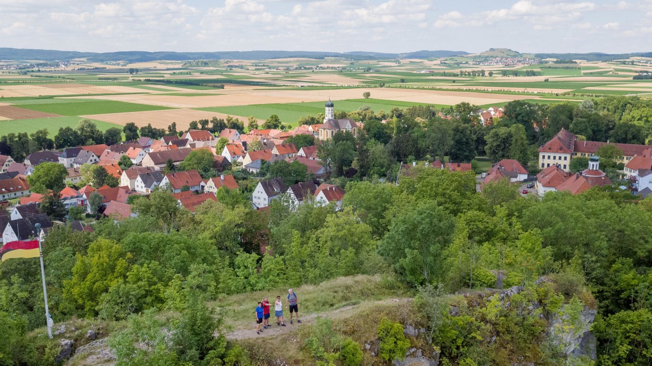 Wanderer stehen auf dem Wallersteiner Felsen mit Blick zum Riesrand