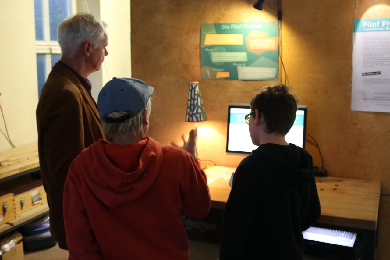 Mit philosophischen Gedankenexperimenten wird überprüft, ob die erarbeiteten Vision und Forderungen gerecht wären. Jugendliche erläutern ihre Arbeit den Besucher*innen der Ausstellung.