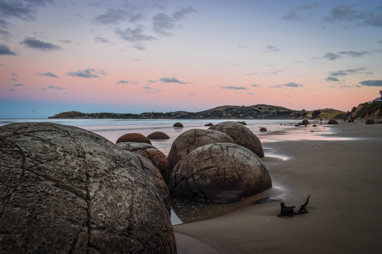 Runde Steinblöcke an einem Sandstrand in Neuseeland (Te Kaihīnaki Moeraki Boulders)