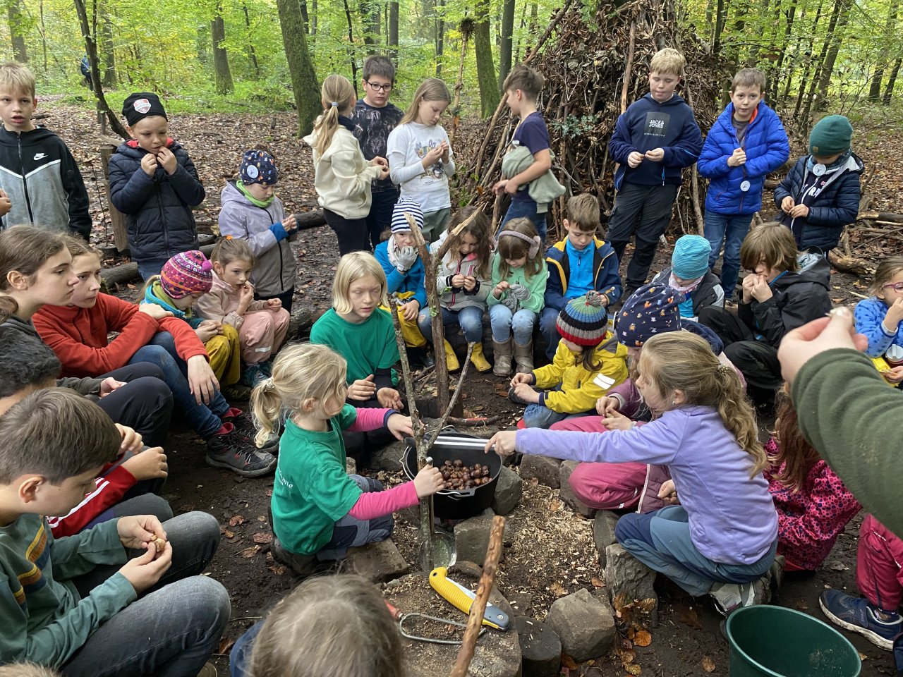 Kinder der Ferienfreizeit im Wildpark grillen Maronen