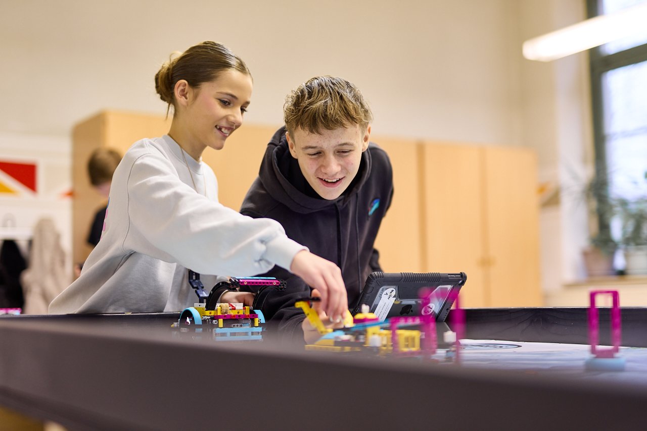 Zwei Schüler:innen programmieren ihren LEGO Roboter bei FIRST LEGO League Challenge