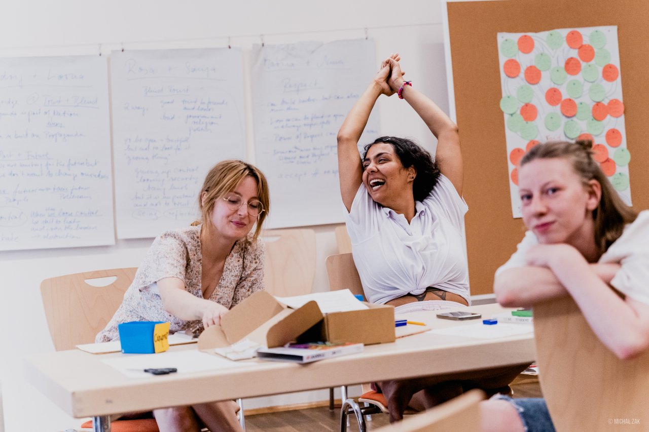 Teilnehmerinnen eines Jugendseminars diskutieren und lachen