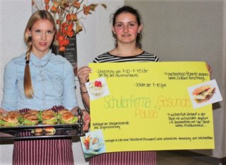 Schülerinnen bieten Essen an und informieren über ihre Schülerfirma