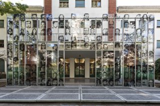 Eingang des ESMA-Museum. Hohe Installation vor dem Gebäude mit großen transparenten schwarz-weiß Porträts.