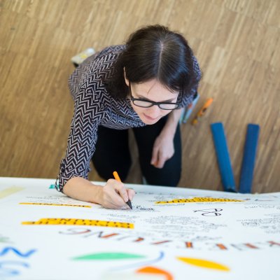 Frau schreibt beim Netzwerktreffen auf Plakat