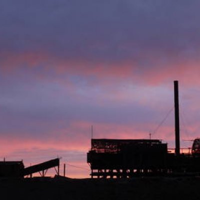 Silhouette einer Salpeteranlage in der Dämmerung.