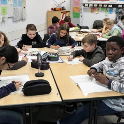 Schülerinnen und Schüler arbeiten selbstständig an einem Gruppentisch