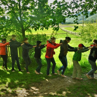 Schüler laufen mit verdeckten Augen in einer Menschenkette 