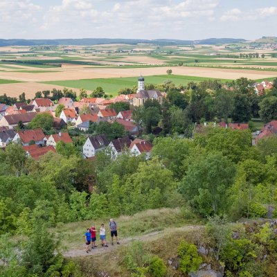 Wanderer stehen auf dem Wallersteiner Felsen mit Blick zum Riesrand